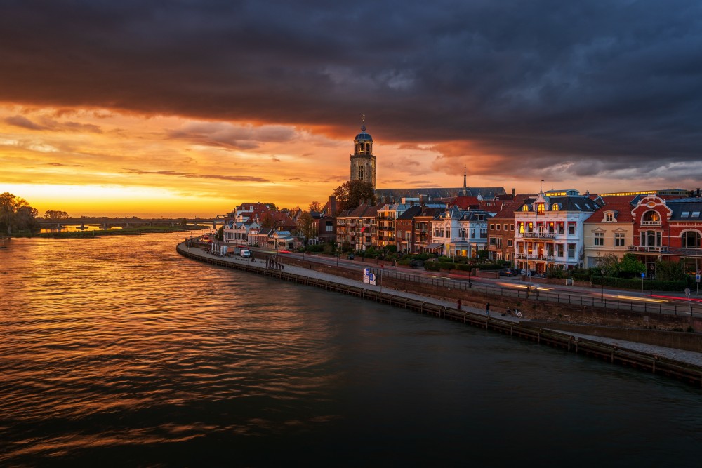 De stad Deventer aan het water met zonsondergang die je kan bezoeken tijdens jouw vakantie in Overijssel. 